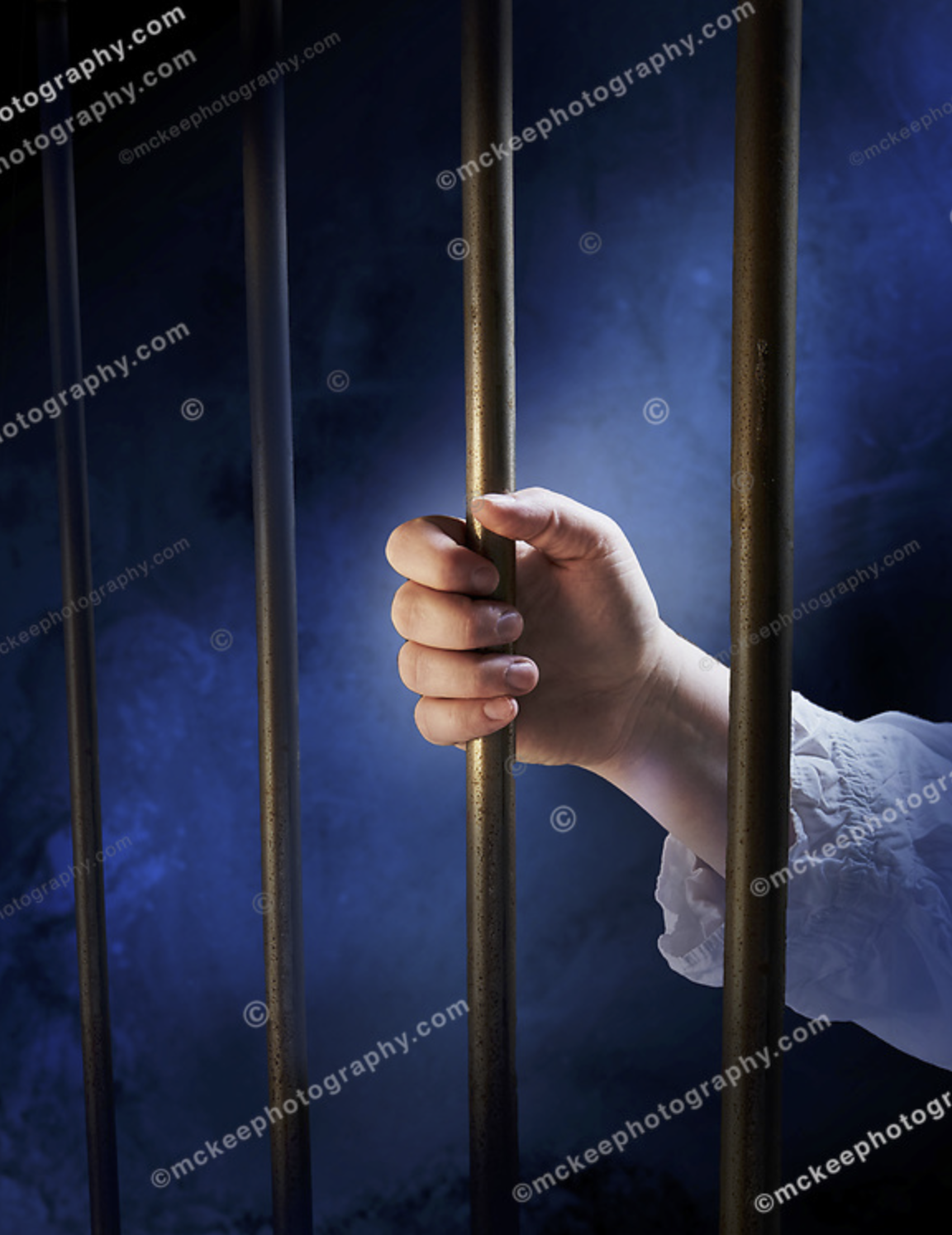 Incarcerated hand holding prison bar stock photo
